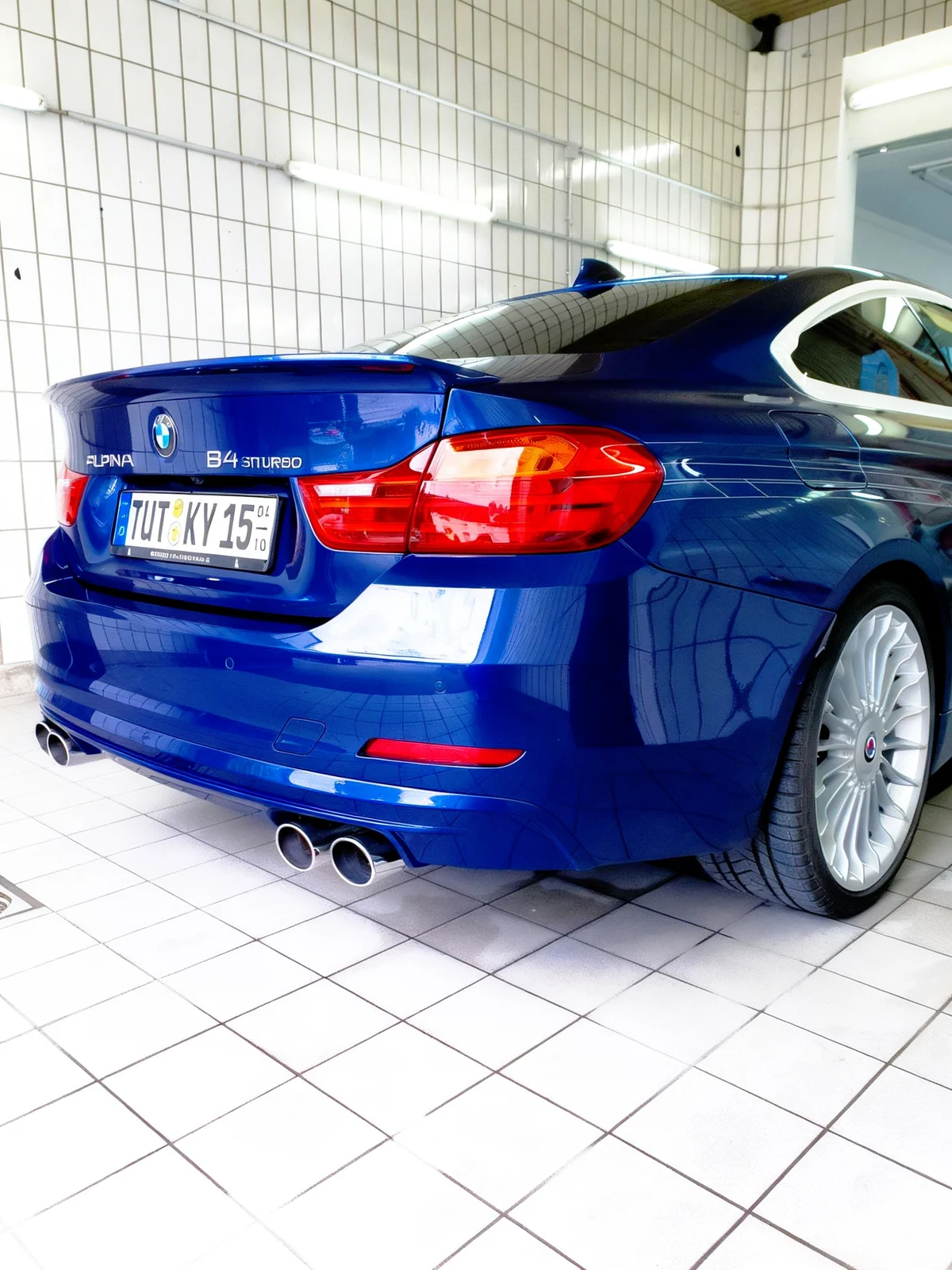 Heckansicht des blauen BMW Alpina mit klaren Lackreflexionen in der Waschhalle